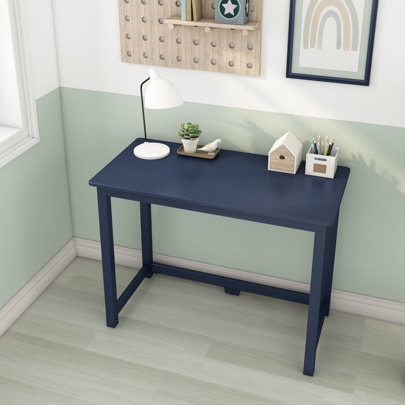 Navy blue minimalist writing desk in a bright home office corner with white desk lamp, succulent, pencil holder and small wooden house decor