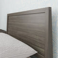 Modern wooden headboard with geometric wallpaper background in stylish bedroom.