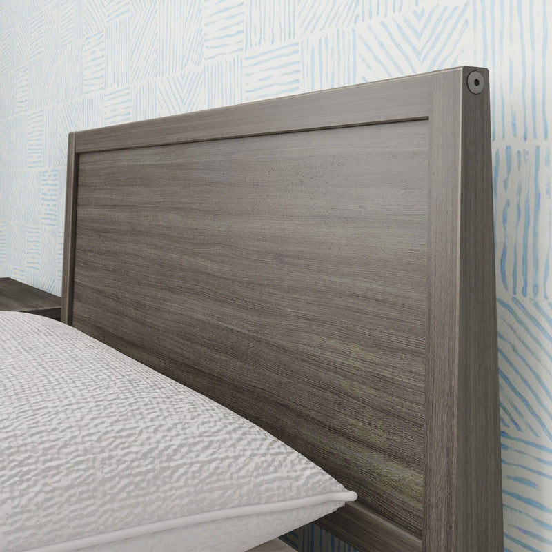 Modern wooden headboard with geometric wallpaper background in stylish bedroom.