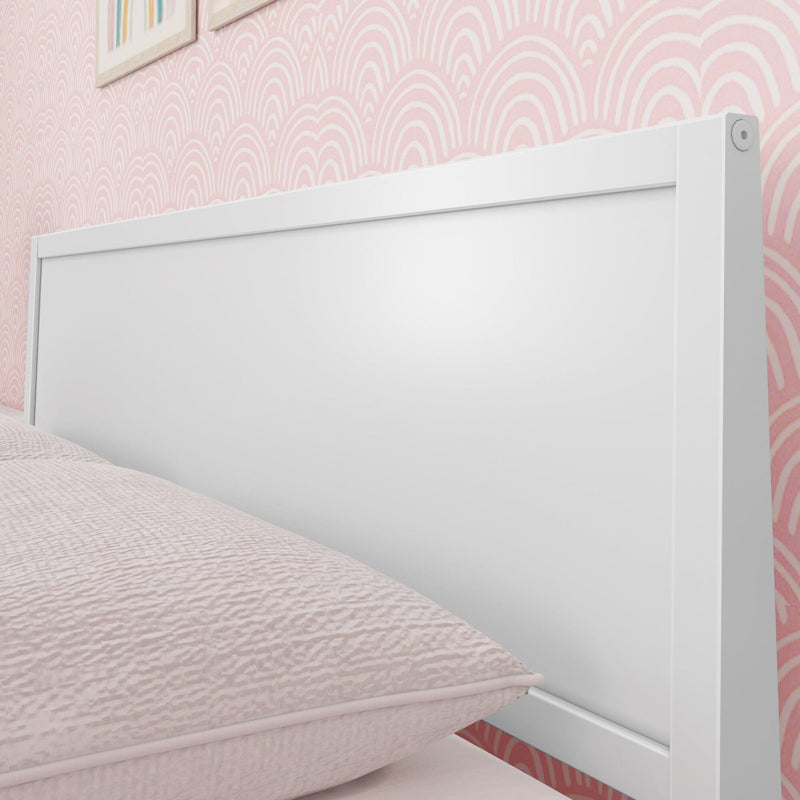 White modern bed headboard against pink patterned wall in a stylish bedroom.