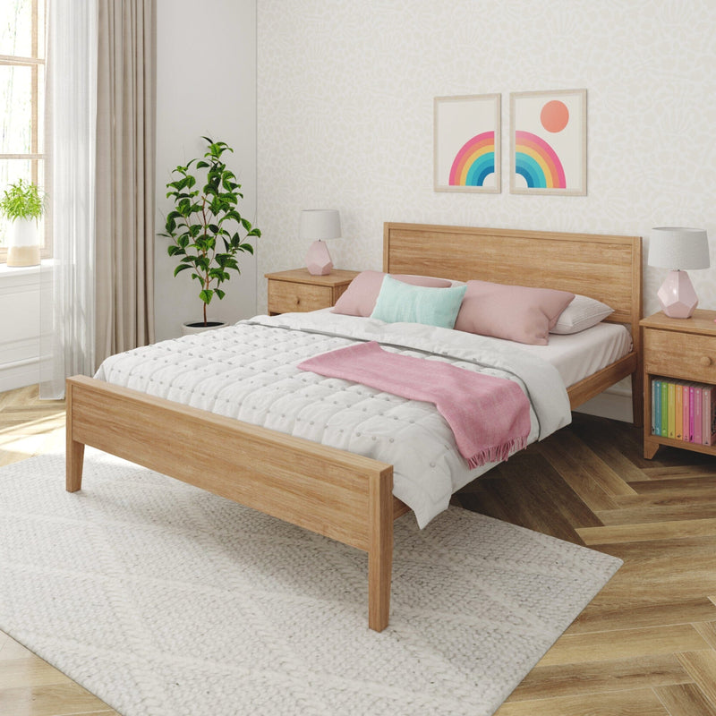 Modern bedroom with wooden bed frame, white bedding, pink and turquoise pillows, and decorative plants.
