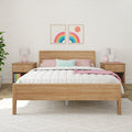 Minimalist bedroom with wooden bed frame, colorful throw pillows, and modern decor accents.