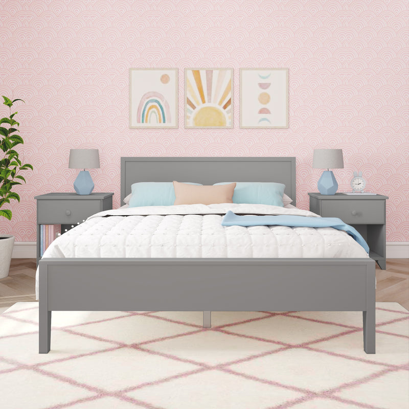 Kids pastel bedroom with grey bed and nightstands, pink scallop wallpaper, watercolor rainbow and sun wall art above headboard, white quilt with pastel blue and peach pillows, blue geometric lamps and pink diamond rug