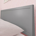 Modern gray wooden headboard with blush pink textured bedding and scallop-patterned pink wallpaper in a contemporary bedroom