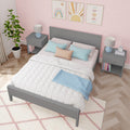 Kids bedroom decor: gray twin bed with pastel pillows, pink scallop wallpaper, gray nightstands with lamps and potted plant.