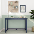 Modern navy blue children's study desk in pastel green kids' room with white desk lamp, wooden pegboard shelves, rainbow wall art, succulent and pencil holder