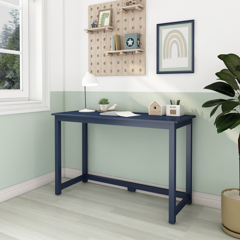 Stylish modern home office desk with navy finish, green accent wall, decorative shelving, and indoor plant.