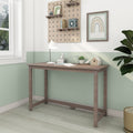 Minimalist wooden console desk in a bright small home office with mint-green half-painted wall, white desk lamp, potted plant, and pegboard shelves