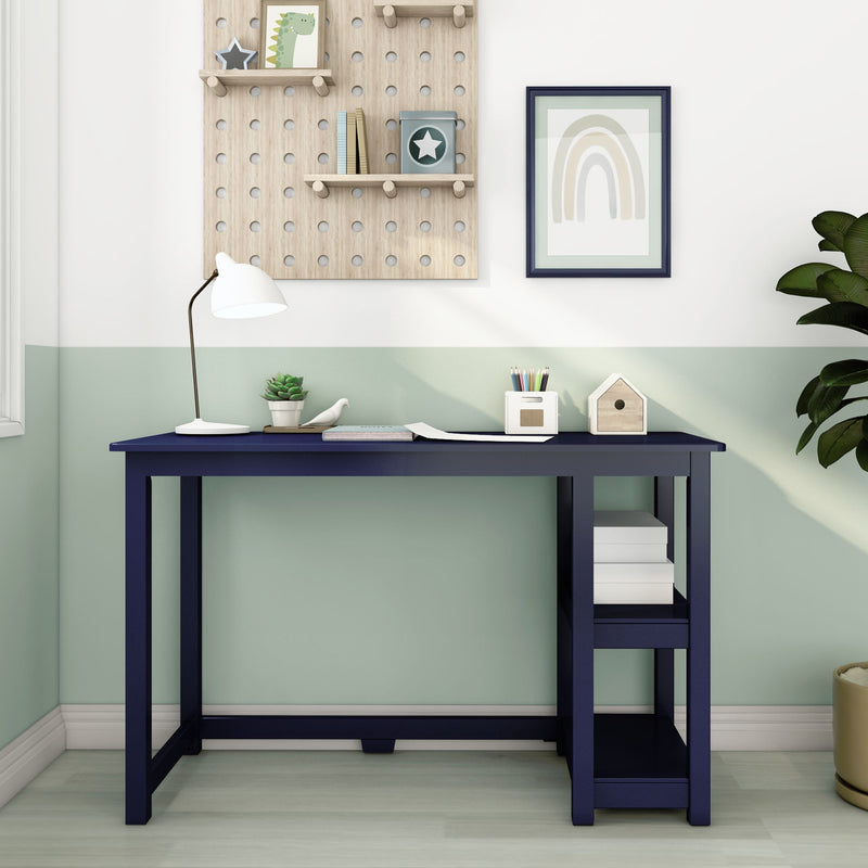 Modern navy blue desk with lamp and shelves in stylish home office setup.