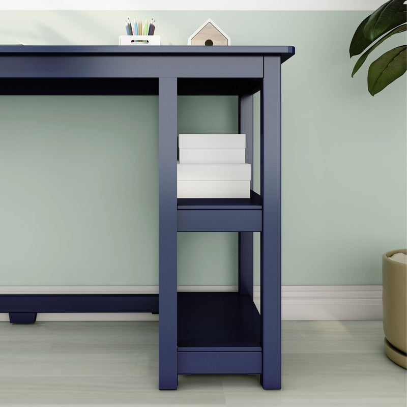 Modern navy blue writing desk with open storage shelves holding white boxes against a mint green wall, home office decor with pencil holder and potted plant