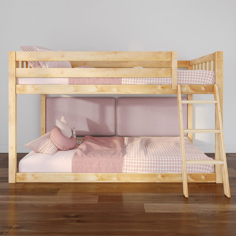 Wooden loft bunk bed with ladder and pink gingham bedding, natural wood frame in a modern kids bedroom with cushioned lower seating and hardwood floor