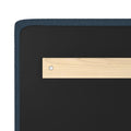 Close-up of navy blue upholstered bed frame corner with black mattress foundation and light wood slat secured by a metal screw