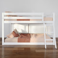 White wooden bunk bed with ladder and peach gingham bedding in a modern kids' bedroom on hardwood floor