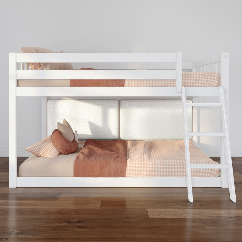 White wooden bunk bed with ladder and peach gingham bedding in a modern kids' bedroom on hardwood floor