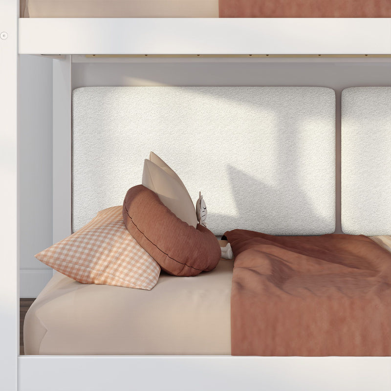 White bunk bed with textured padded headboard, beige gingham pillow, rust-colored bedding and round cushion, small plush toy, neutral kids bedroom decor