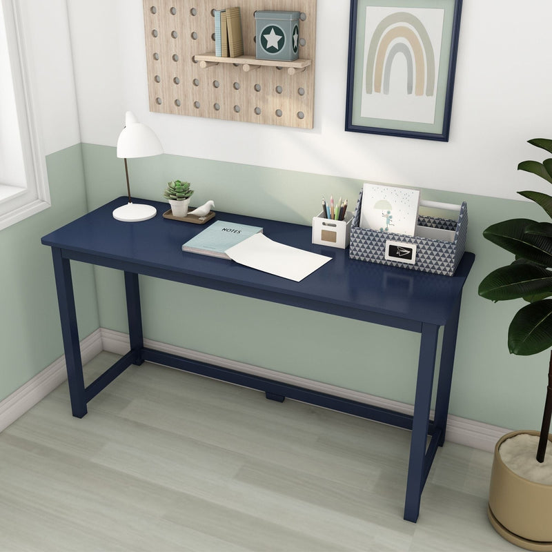 Navy blue writing desk in a modern home office with white lamp, stationery organizer, notebook and potted plant against a mint-green half-painted wall