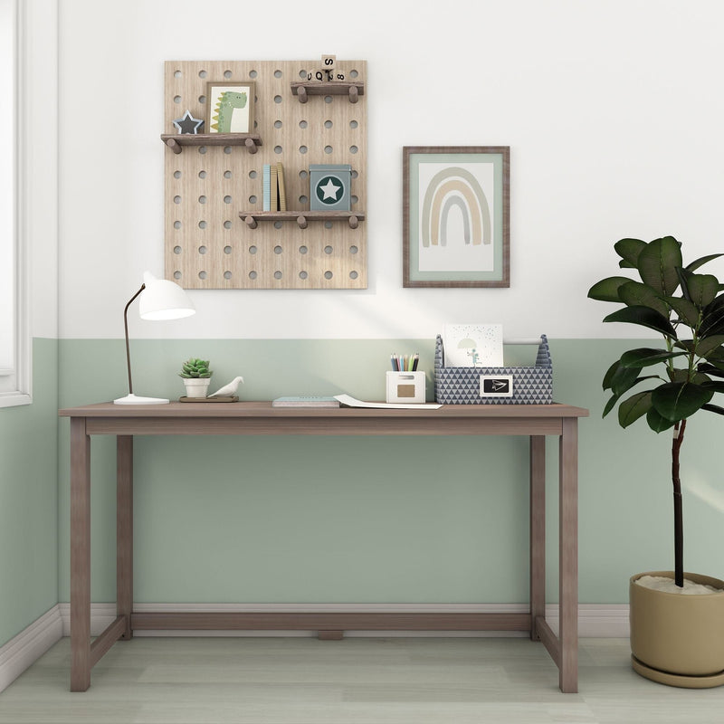 Minimal wooden desk in pastel mint nursery, featuring pegboard shelves with decor, white desk lamp, potted plant, rainbow wall art and stationery organizer