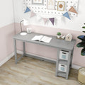 Small gray kids study desk with built-in storage shelves, lamp, open book and succulent in pastel pink nursery with bunting garland and wood floor
