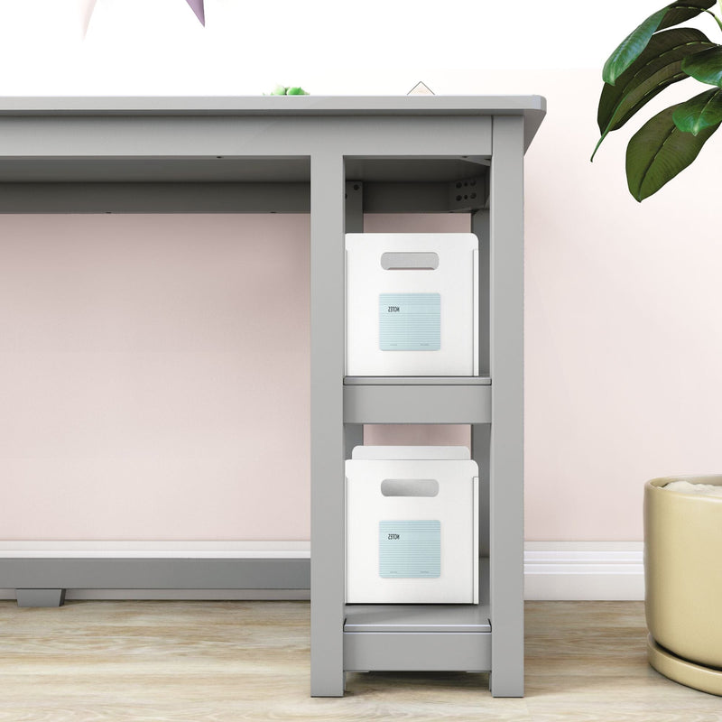 Modern gray desk with built-in under-desk shelving holding two white storage bins labeled "NOTES" against a pastel pink wall — minimalist home office organization and small-space storage solution