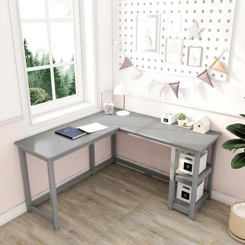 L-shaped gray corner desk with built-in shelving in a bright pink and white home office study nook by a window, modern small-space workstation with pegboard wall decor, bunting, lamp and storage boxes
