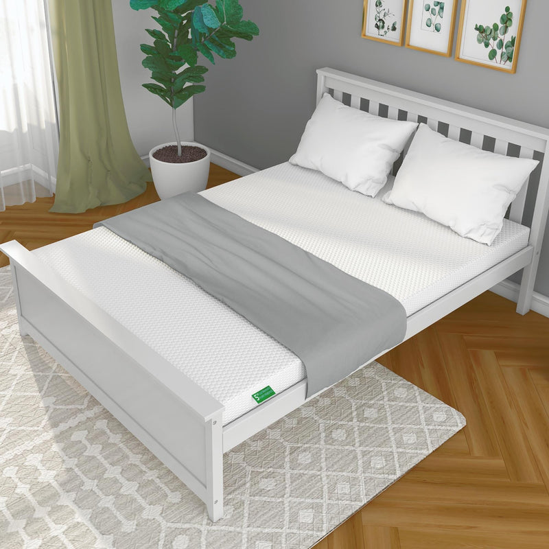 Modern bedroom featuring a white wooden bed frame with a comfortable mattress, crisp white bedding, and a green plant for a fresh look.