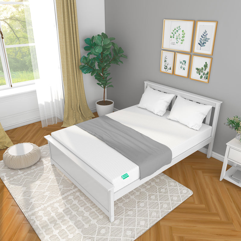Modern bedroom interior with white bed frame, gray and white bedding, wooden floor, and decorative plant.