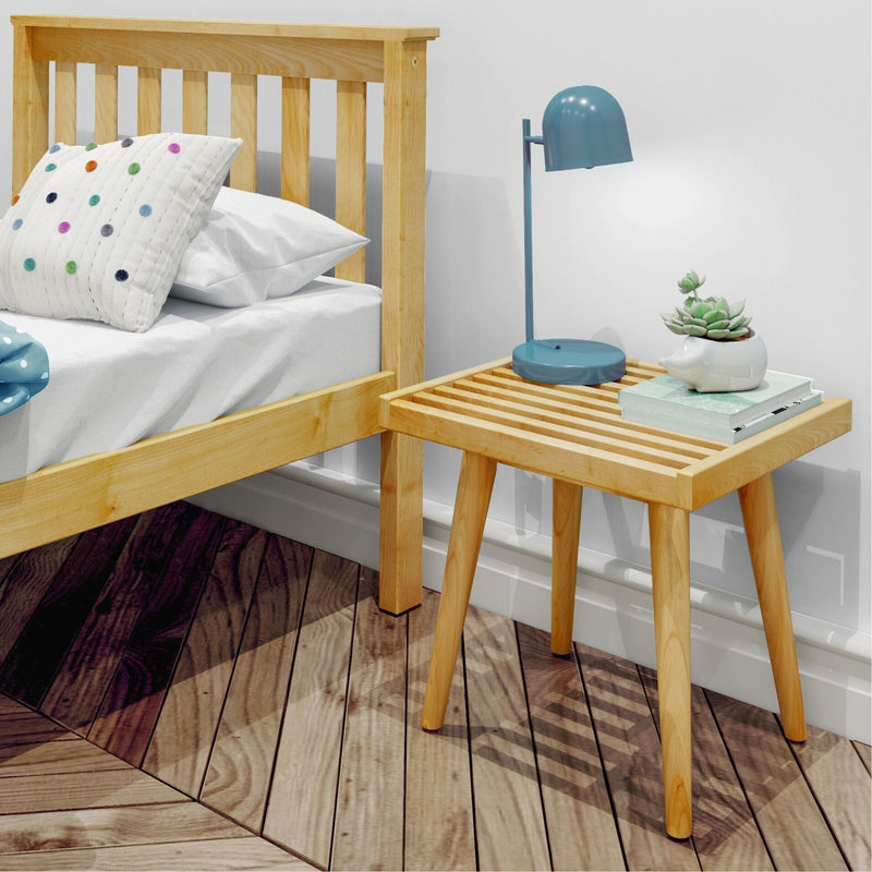 Wooden bed with polka dot pillow and modern wooden nightstand featuring a blue lamp and succulent plant.