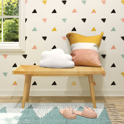Children's nursery with pastel triangle wallpaper, wooden bench, cloud-shaped cushion, yellow-pink striped pillow and teal rug