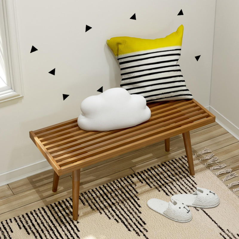 Cozy modern seating area with wooden bench, striped cushion, and decorative cloud pillow.