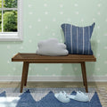 Cozy Scandinavian-themed room with wooden bench, geometric wallpaper, and decorative pillows.