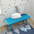 Modern children's room with blue bench, cloud pillow, cozy slippers, and geometric wall decor.
