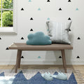 Modern interior with wooden bench, decorative pillows, and cozy slippers in a stylish living room.