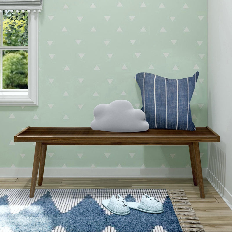 Modern interior with wooden bench, cloud-shaped cushion, and blue-striped pillow in a cozy living space.