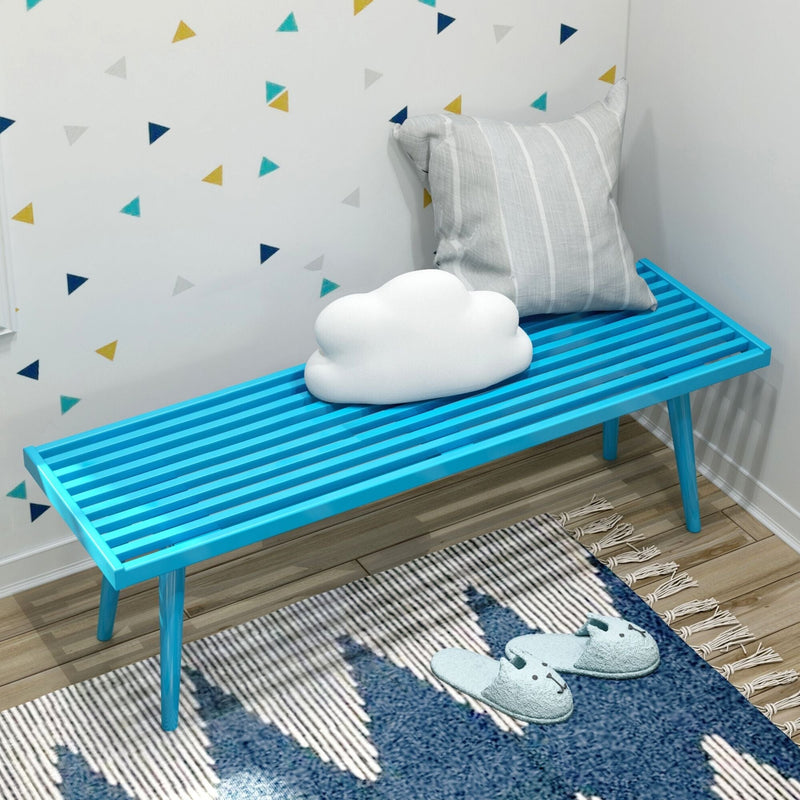 Modern blue bench with cloud and striped pillows on geometric wallpaper background in cozy living space.