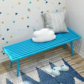 Modern blue bench with cloud and striped pillows on geometric wallpaper background in cozy living space.