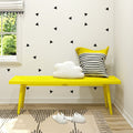 Cozy corner with a yellow bench, striped pillow, and fluffy cloud decoration in a modern living room.