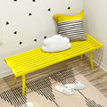 Bright yellow bench with decorative pillows in modern interior design.