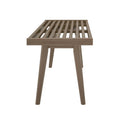 Mid-century modern wooden bench with slatted design and tapered legs, side view.