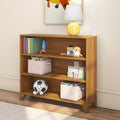 Wooden children's bookshelf in bright nursery decor with yellow table lamp, colorful books, toy rocket, wooden camera, stacked alphabet blocks and fabric storage bins for toy organization in kids room
