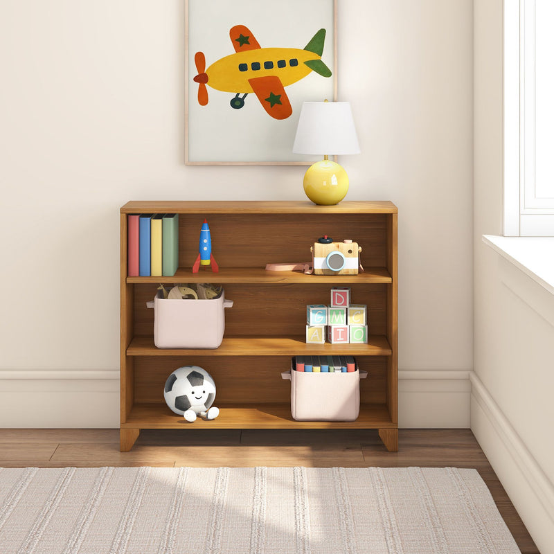 Kids room decor - wooden storage shelf with framed airplane wall art, yellow lamp, toy rocket, wooden camera, alphabet blocks, fabric bins and smiling soccer ball
