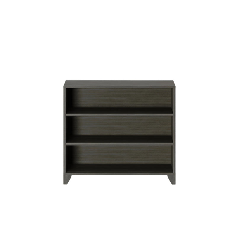 Gray wooden three-shelf bookcase on a white background.