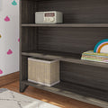 Dark wooden shelf with a vintage radio, storage basket, and children's books in a kids' room with cloud wall decals.