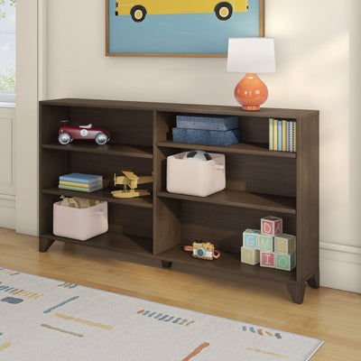 Wooden kids cubby shelf in nursery with toys, fabric storage bins, alphabet blocks, red toy car, orange lamp and books on hardwood floor
