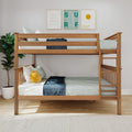 Solid wood twin-over-twin bunk bed with ladder and guardrails in a modern kids' bedroom, light blue bedding, navy throw, smiling sun plush pillow, surf and sunshine wall art, potted plant on hardwood floor