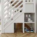 White wooden loft bunk bed with built-in cubby shelves and under-bed storage, stacked books and navy sneakers on herringbone hardwood floor