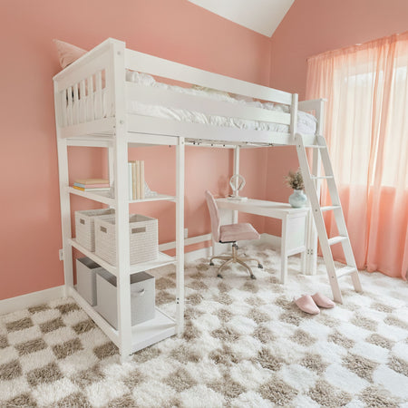Pink kids' bedroom with white loft bed and ladder, built-in shelves and study desk, woven storage baskets and plush checkered shag rug.