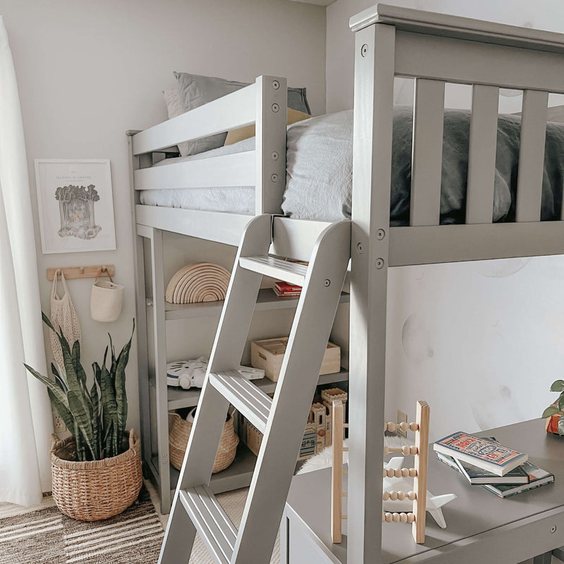 Modern grey wooden loft bed with a ladder in a stylish and cozy children's room featuring a plant, toys, and books for a minimalist decor.