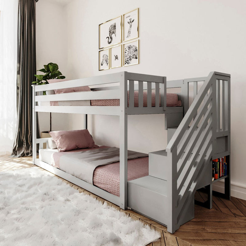 Gray wooden bunk bed with stairs and pink bedding in a modern, cozy bedroom setting.