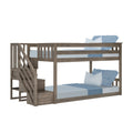 Rustic gray wooden bunk bed with built-in staircase and storage, twin-over-full frame with blue pillows and bedding for kids' bedroom