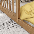 Close-up of natural wood slatted bed frame with white striped mattress, yellow duvet and black-and-white textured rug